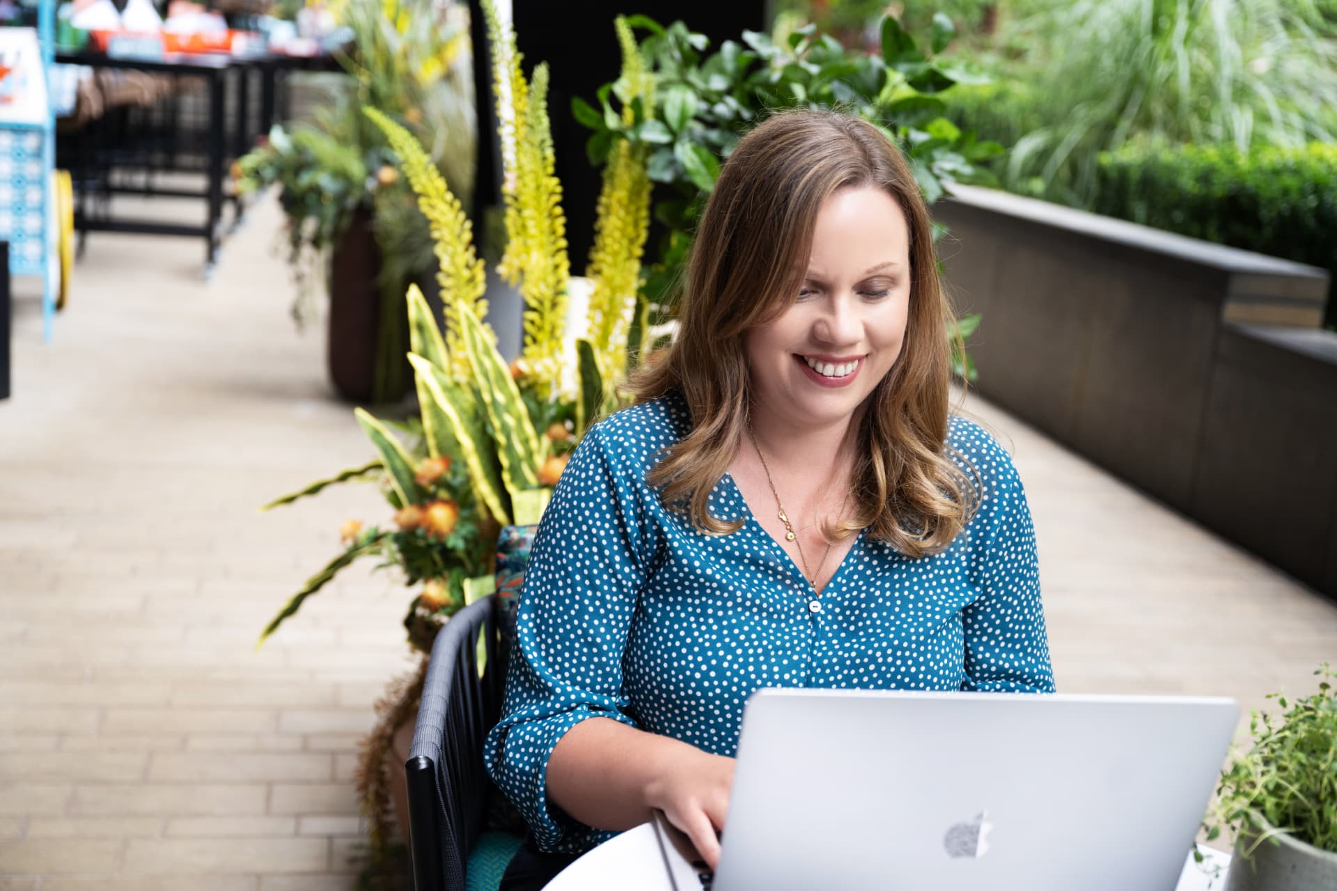 Jo working at a laptop outdoors, mid-conversation